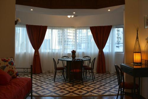 a living room with a table and chairs and curtains at Teatros Buenos Aires - Amplio y Cómodo en Gran ubicación 5 personas Cuidamos tu estadía! in Buenos Aires