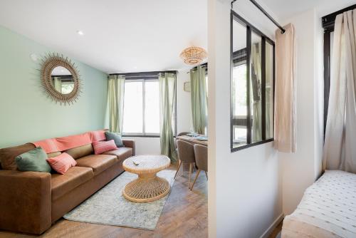 Suites Gaya Confort - Centre Ville في مونبلييه: غرفة معيشة مع أريكة وطاولة