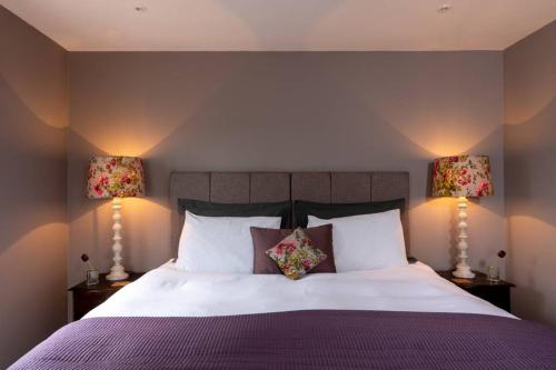 a bedroom with a large bed with two lamps at The Old Engineer A rural boutique retreat in Yalding