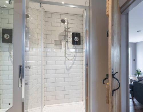a bathroom with a shower with white tiles at The Old Engineer A rural boutique retreat in Yalding