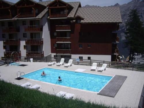 a swimming pool in front of a building at Marmottin1 in Puy-Saint-Vincent