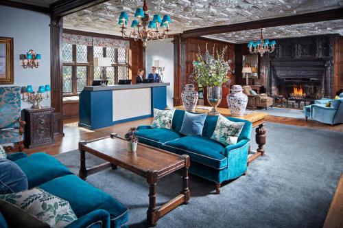 a living room with blue couches and a table at Great Fosters - Near Windsor in Egham