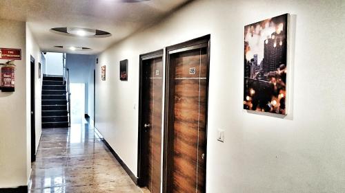 a hallway with wooden doors and a picture on the wall at Hotel Aerocity Purple Orchid in New Delhi