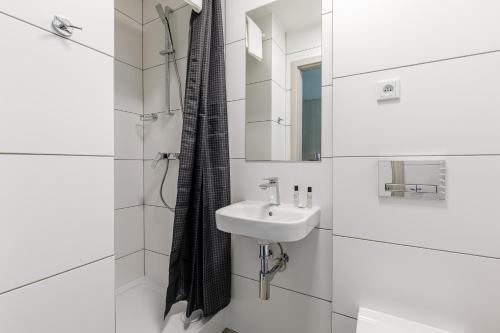 a white bathroom with a sink and a mirror at AQUA HOUSE in Sopot