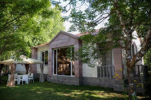 a pink house with a table and an umbrella at Garden Inn Resort Sevan in Sevan