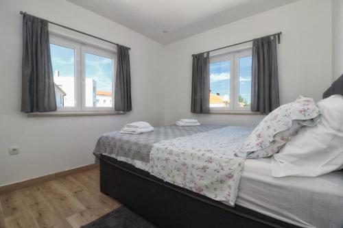 - une chambre avec un lit et 2 fenêtres dans l'établissement Apartments Korina & Dadi, à Rovinj