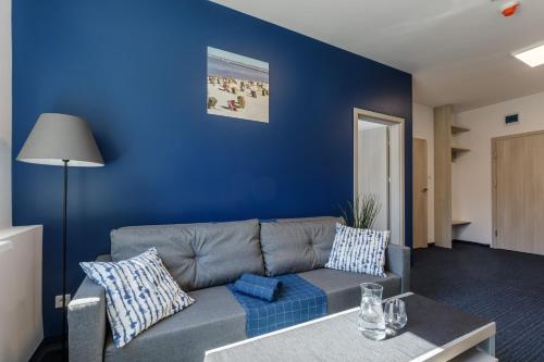 a living room with a couch and a blue wall at AQUA HOUSE in Sopot