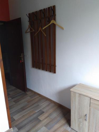 a room with wooden hangers on a white wall at Pension Family Club in Libišany