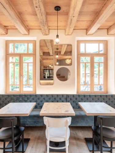 a restaurant with wooden ceilings and tables and chairs at Alla Stazion Locanda nelle Dolomiti in Pieve di Cadore
