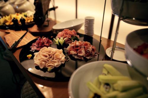 three muffins on plates on a table with food at Hotel Kalos in Budva