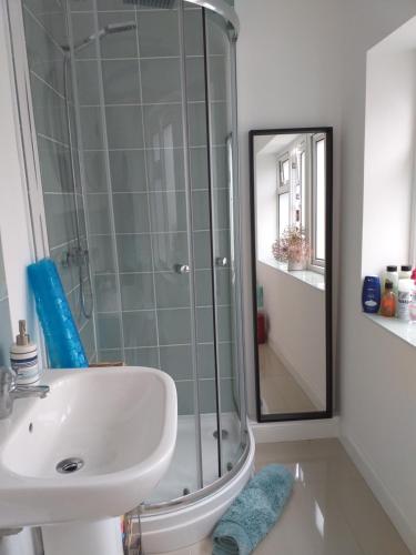 a bathroom with a sink and a glass shower at Offa Hideaway in Leamington Spa