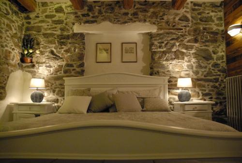 a bedroom with a large bed and two lamps at Chalet in pietra e legno con caminetto in Inverso Pinasca