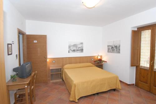 a bedroom with a bed and a tv in it at Le antiche Torri in Pescasseroli