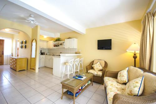 a living room with a couch and a table at Antigua Village Beach Resort in Saint Johnʼs