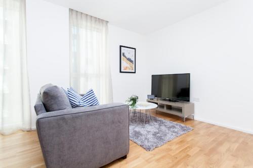 a living room with a couch and a television at Clover Court in London