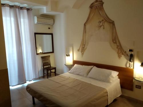 Un dormitorio con una cama grande y una ventana en Hotel Vittorio Veneto Napoli, en Nápoles