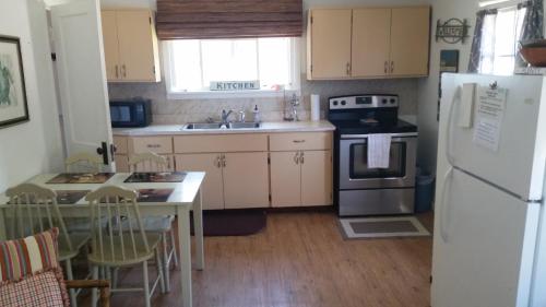 uma cozinha com um frigorífico branco e uma mesa com cadeiras em Bay Port Lodging em Frankfort