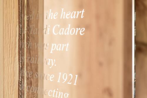 a chalkboard sign on a wooden wall with the words the heart of cadore at Alla Stazion Locanda nelle Dolomiti in Pieve di Cadore