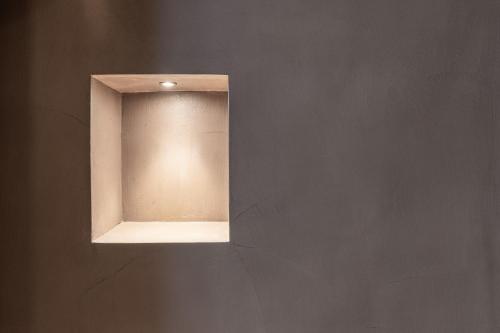 a light on a wall in a room at Alla Stazion Locanda nelle Dolomiti in Pieve di Cadore