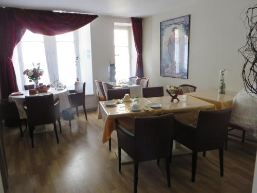 une salle à manger avec tables, chaises et fenêtres dans l'établissement Hotel Régina, à Besançon