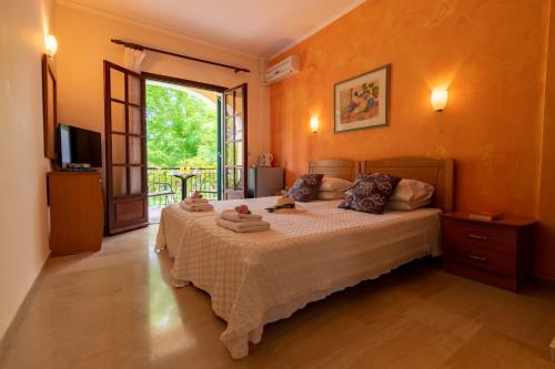 a bedroom with a bed and a sliding glass door at Villa Litsa in Ermones
