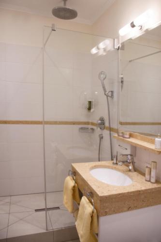 a bathroom with a sink and a shower at Thermenhotel Quellenhof in Bad Füssing