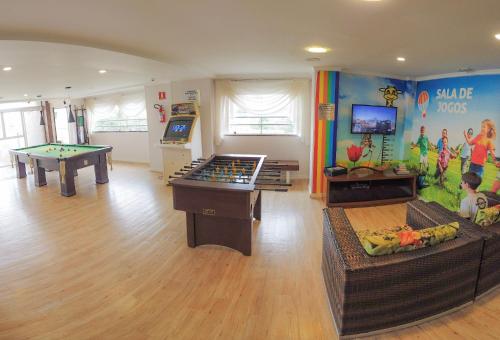 a childrens play room with two tables and pool tables at Del Rey Quality Hotel in Foz do Iguaçu