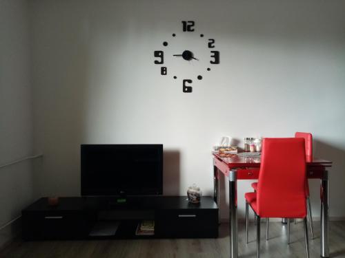 Habitación con escritorio y reloj en la pared en apartmán Aneta, en Karlovy Vary