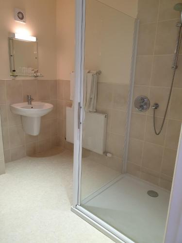 a bathroom with a shower and a sink at the old red lion in Bruton