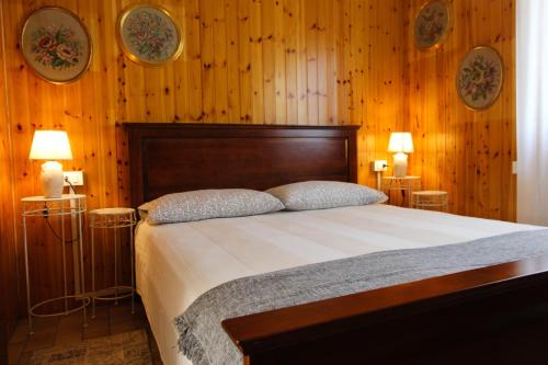 a bedroom with a large bed with wooden walls at La petite maison in Sirmione