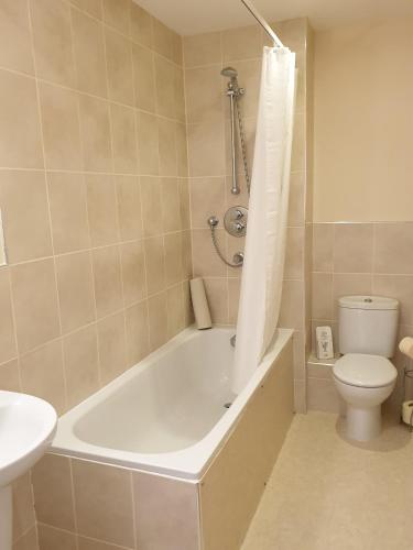 a bathroom with a tub and a toilet and a sink at the old red lion in Bruton