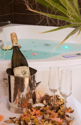 a bottle of champagne in a bucket next to two wine glasses at Garden Spa Boutique Hotel in Skopje
