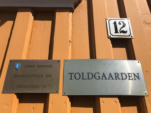 a sign on a building that reads toledgmentangering at Tollgaarden Gjestegaard in Larvik