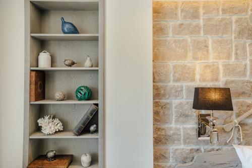 a book shelf with vases and a lamp and a brick wall at Boutique Hotel Casa del Mare - Vizura in Kotor