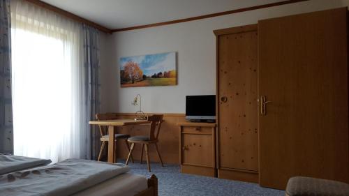 a bedroom with a desk and a bed and a desk with a computer at Gästehaus Pehab in Gröbming