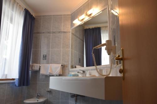 a bathroom with a sink and a mirror at Garni Haus Tyrol in Corvara in Badia