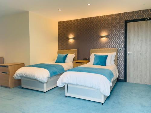 a hotel room with two beds and a desk at Barmouth Beach Club in Barmouth