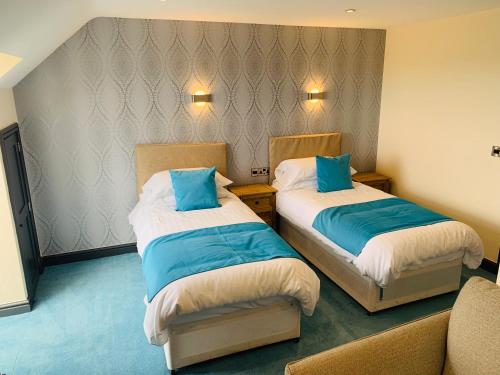 a hotel room with two beds and two nightstands at Barmouth Beach Club in Barmouth