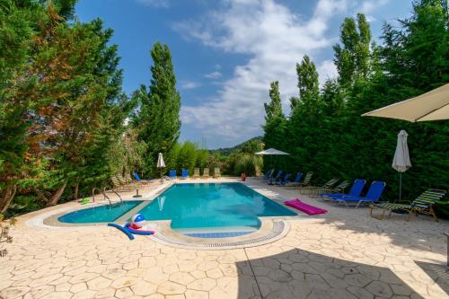 a pool with chairs and umbrellas at a resort at Villa Litsa in Ermones