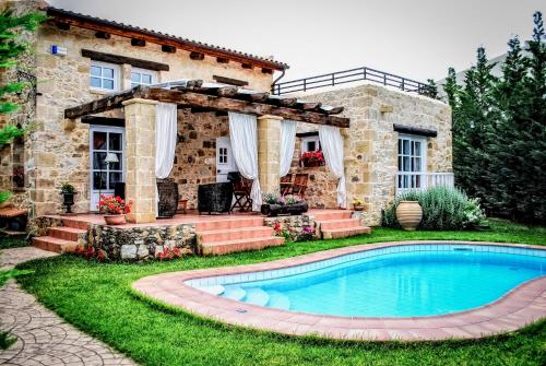 a stone house with a swimming pool in the yard at Rock House's Villa Melody in Plataniás