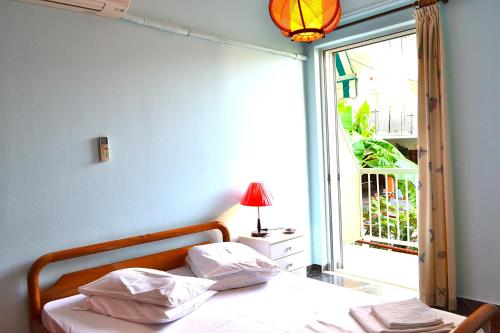 a bedroom with a bed and a window and a lamp at Oniro Apartments in Xiropigado