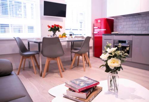 a living room with a table with books and a vase of flowers at Quiet Central West End Apartments by Indigo Flats in London