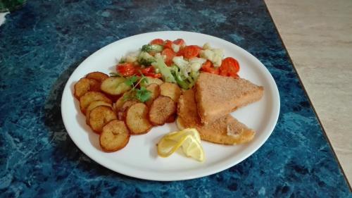 a white plate of food with toast potatoes and vegetables at Penzión Príjemný Oddych in Banská Štiavnica