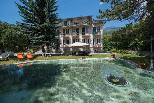 einem großen Pool vor einem Gebäude in der Unterkunft La Grande Eperviere in Barcelonnette