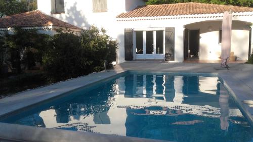 a swimming pool in front of a house at frederique lavande bleue in Le Luc