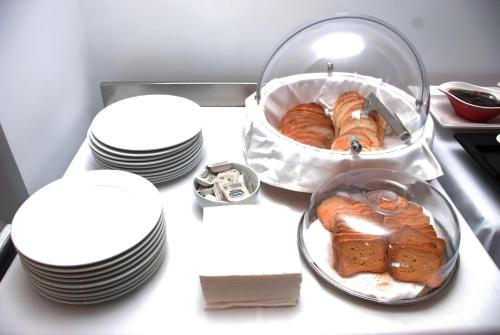 a table with plates and a bowl of croissants at Hotel Sole in Sarandë
