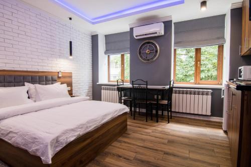 ein Schlafzimmer mit einem Bett und einem Tisch darin in der Unterkunft Vip Apartment near Arena City in Kiew