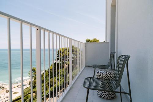 a balcony with two chairs and a view of the beach at NUMA HOTEL in Numana