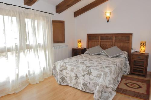een slaapkamer met een bed en een groot raam bij El Balcon De La Catedral in El Burgo de Osma