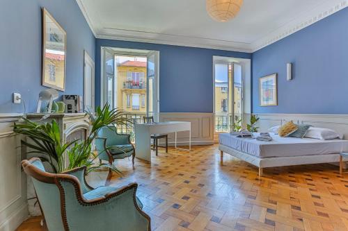 - une chambre avec des murs bleus, un lit et une table dans l'établissement Maison Bianchi - 24 Paul Deroulede, à Nice